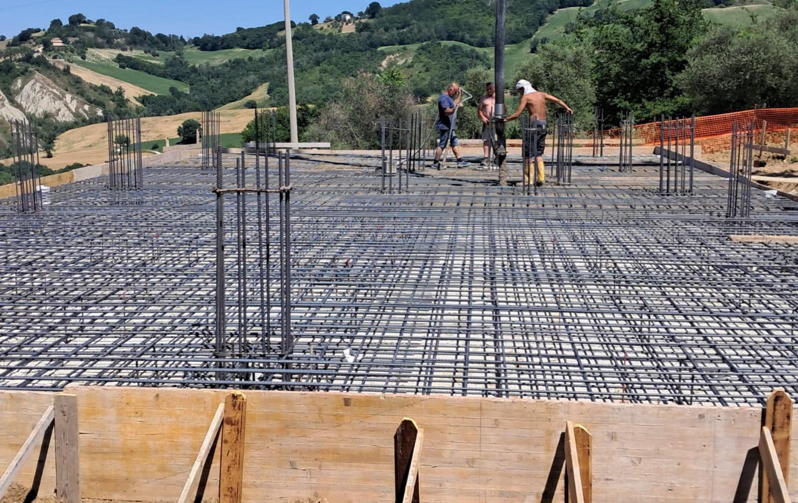 L’armatura del solaio prima del getto, con le maestranze al lavoro e la vallata sullo sfondo.
